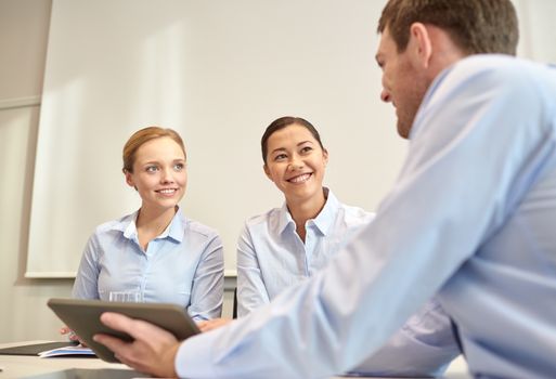 business, people, technology and teamwork concept - smiling businessman and businesswomen with tablet pc computer meeting in office