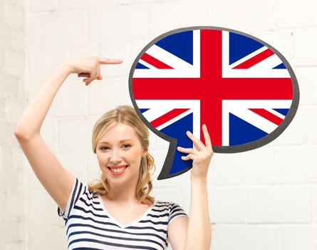 education, foreign language, english, people and communication concept - smiling woman holding text bubble of british flag and pointing finger