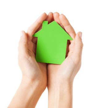 real estate and family home concept - closeup picture of female hands holding green blank paper house