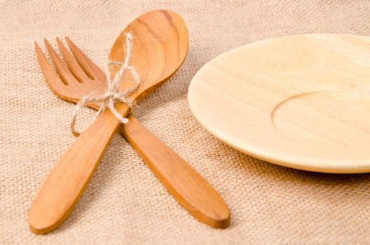 Handcrafted wooden kitchen utensils on sack background