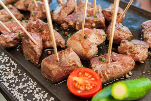 grilled barbecue meat on sticks served with vegetables