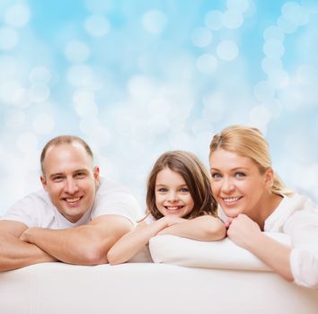 family, childhood, holidays and people - smiling mother, father and little girl over blue lights background