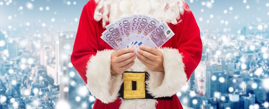 christmas, holidays, winning, currency and people concept - close up of santa claus with euro money over snowy city background