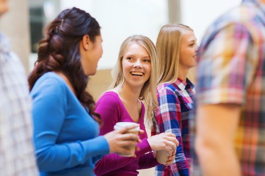 education, high school, friendship, drinks and people concept - group of smiling students with paper coffee cups