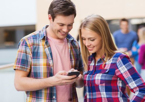 friendship, people, technology and education concept - group of smiling students with smartphone outdoors