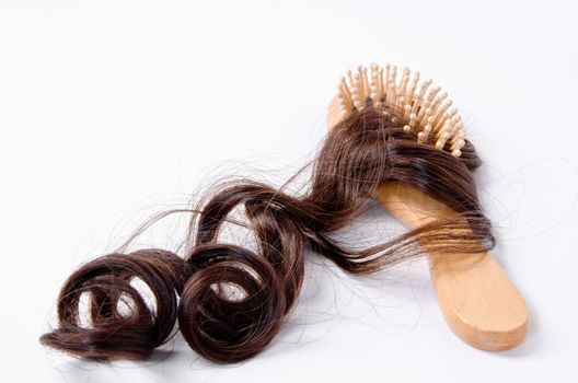 wooden comb brush with hair, on white background