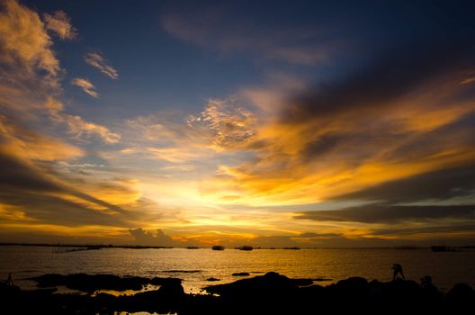 sunset on the beach with beautiful sky and Silhouette of young photographer