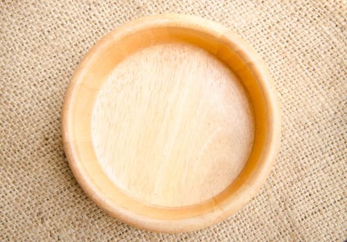 empty wooden bowl on sack background