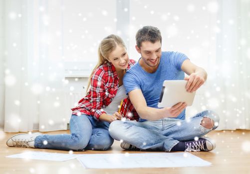 repair, building, renovation, technology and people concept - smiling couple with blueprint looking at tablet pc at home