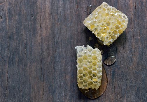 Honeycomb with honey over old wooden table