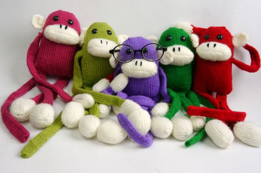 Family of stuffed animal sit at new year party, group of knitted monkey in colorful yarn, symbol of 2016, funny homemade toy on white background, handmade food and calendar to happy new year