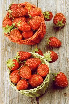 Ripe Forest Strawberries in Two Wicker Baskets closeup on Textured Wooden background