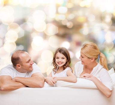 family, childhood, holidays and people - smiling mother, father and little girl over lights background