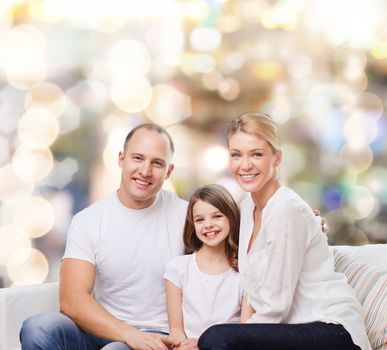 family, childhood, holidays and people - smiling mother, father and little girl over lights background