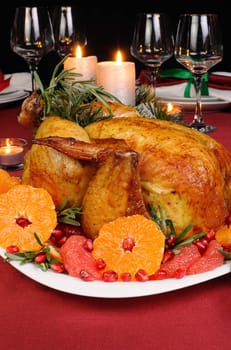 Baked chicken with mandarin, grapefruit, pomegranate at the Christmas table