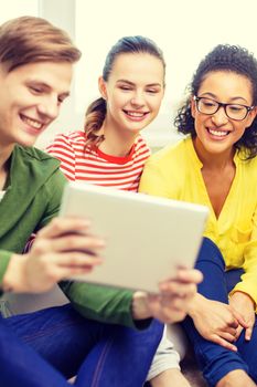 education and technology concept - smiling students with tablet pc computer at home