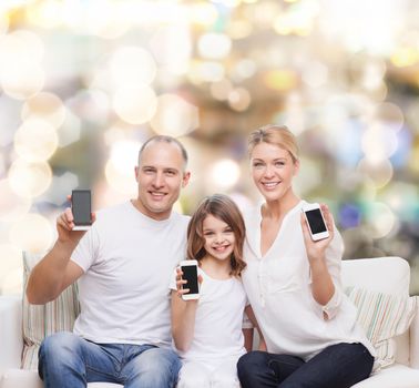 holidays, technology, advertisement and people concept - smiling family with smartphones over lights background