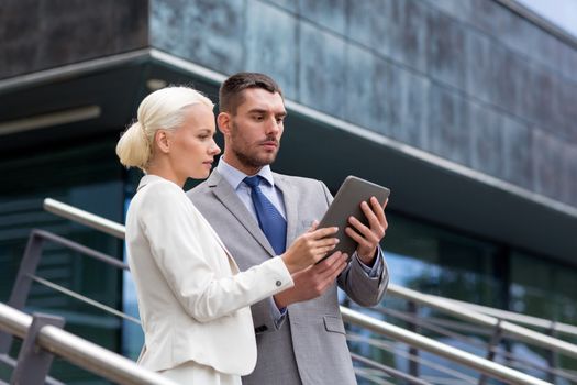 business, partnership, technology and people concept - businessman and businesswoman working with tablet pc computer on city street