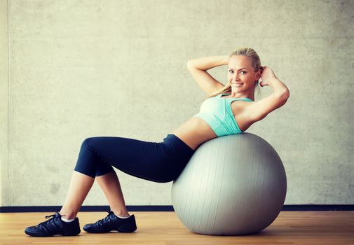 fitness, sport, training and lifestyle concept - smiling woman with exercise ball in gym