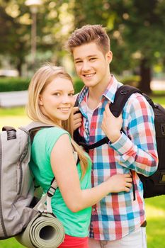 travel, vacation, tourism and friendship concept - smiling couple with backpacks in nature