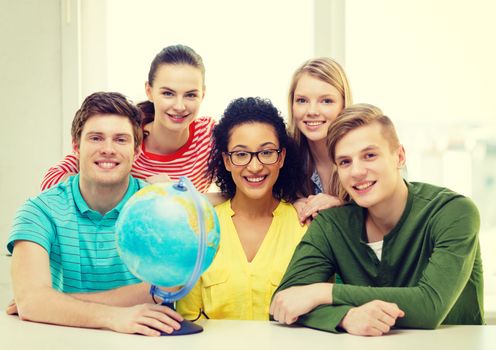 education, travel and geography concept - five smiling student with earth globe at school