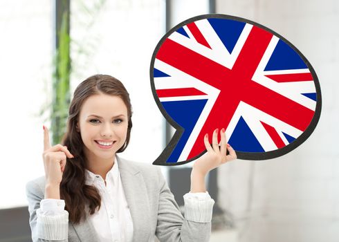 education, foreign language, english, people and communication concept - smiling woman holding text bubble of british flag and pointing finger up