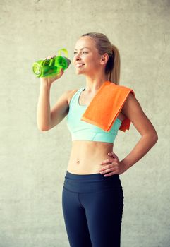 fitness, sport, training, drink and lifestyle concept - woman with bottle of water in gym