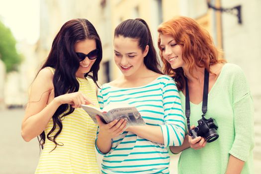 tourism, travel, leisure, holidays and friendship concept - smiling teenage girls with city guide and camera outdoors