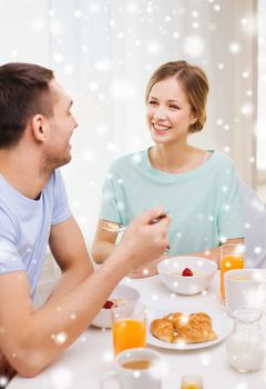 food, home, people and happiness concept - smiling couple having breakfast at home