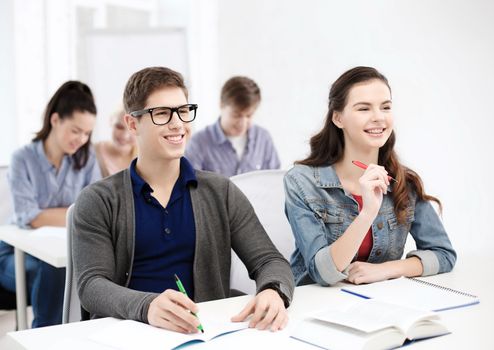 school and education concept - group of smiling students with notebooks at school