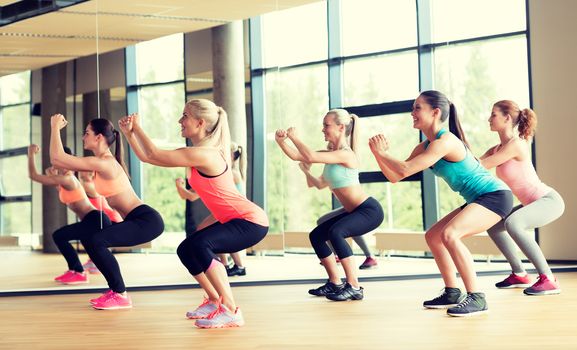 fitness, sport, training, gym and lifestyle concept - group of women working out in gym