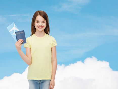 travel, holiday, vacation, childhood and transportation concept - smiling little girl with airplane ticket and passport