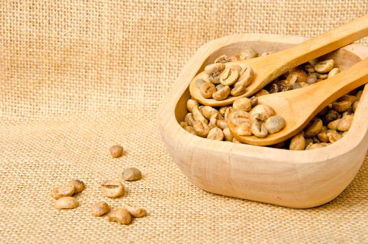 Coffee beans on wooden spoons and cup , on sack