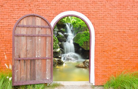 Old door wooden is open to waterfall wall