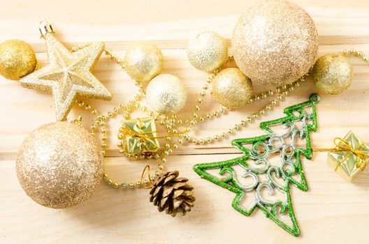 Golden Christmas decorations on wooden background.