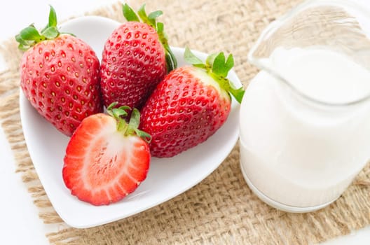 Fresh Strawberries and milk drink on sack background.