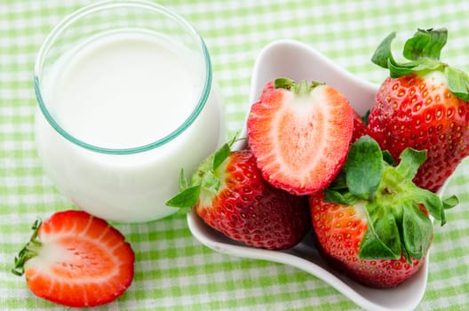Fresh Strawberries and milk drink on tablecloth background.