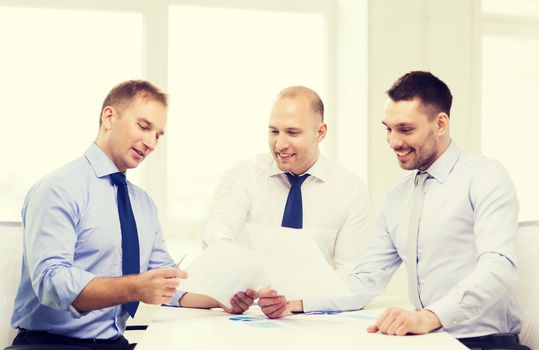 business and office concept - smiling businessmen with papers in office