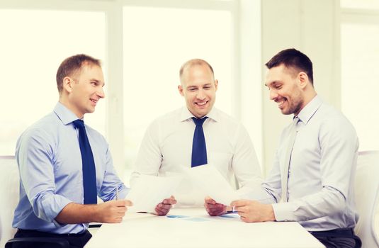 business and office concept - smiling businessmen with papers in office