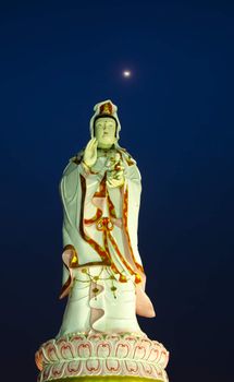 Golden statue of chinese female god, background night time of moonlight