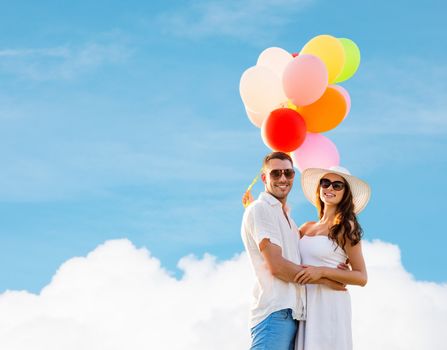 love, wedding, summer, dating and people concept - smiling couple wearing sunglasses with balloons hugging over blue sky and cloud background