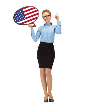 education, foreign language, english, people and communication concept - smiling woman holding text bubble of american flag and pointing finger up