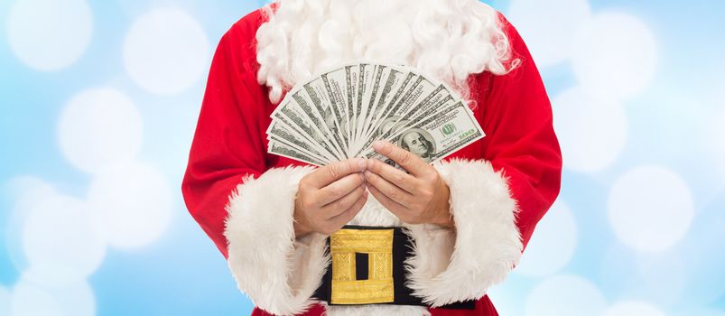christmas, holidays, winning, currency and people concept - close up of santa claus with dollar money over blue lights background