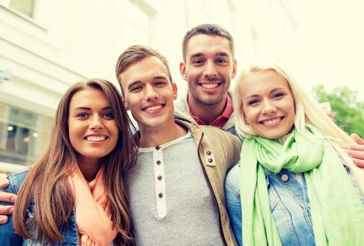 travel, vacation and friendship concept - group of smiling friends in city