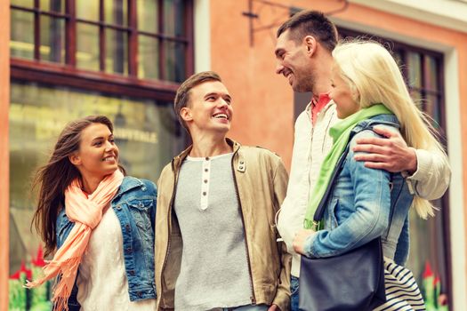 friendship, travel and vacation concept - group of smiling friends walking in the city