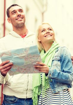 travel, vacation and friendship concept - happy couple with city map exploring city
