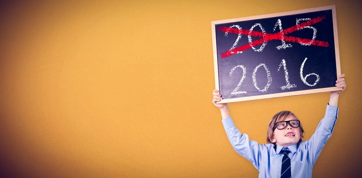 Cute pupil holding chalkboard against orange background