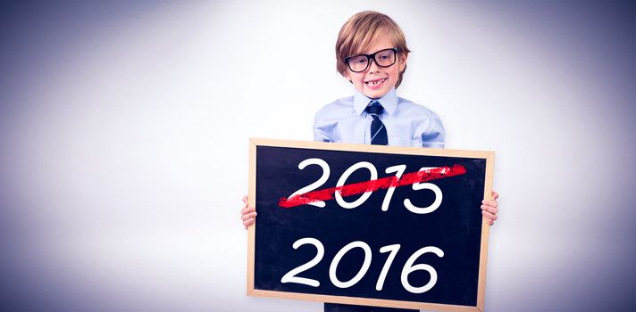 Cute pupil holding chalkboard against grey background