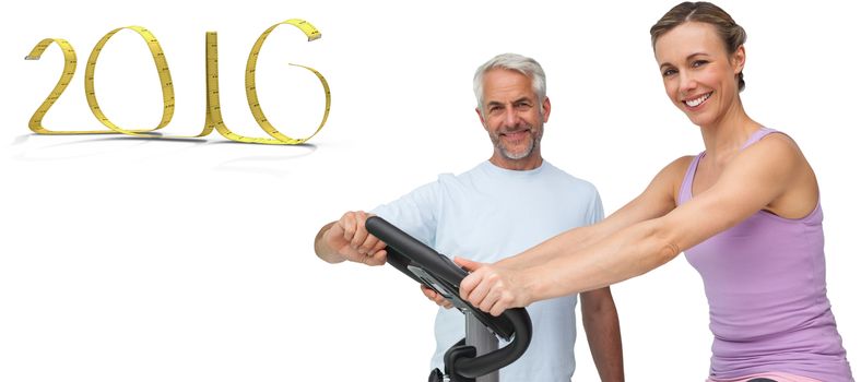 Portrait of a happy woman on stationary bike with trainer against white background with vignette