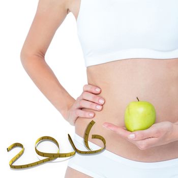 Woman holding an apple in front of her belly  against white background with vignette